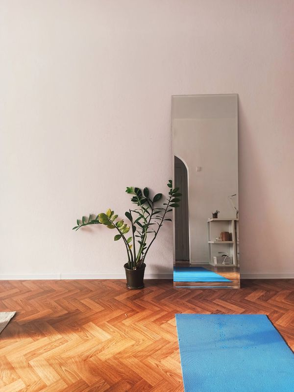 A bright, airy room with a yoga mat and plants.